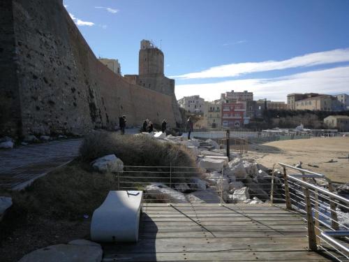 une passerelle en bois à côté d'un mur avec un bâtiment dans l'établissement Azzurro come il Mare, à Termoli