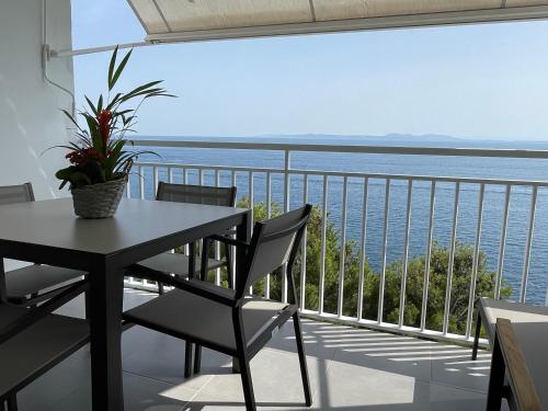 a balcony with a table and chairs and a view of the ocean at OverTheSea - PUEBLECITO Apartment in Roses