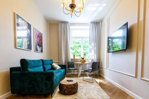 ein Wohnzimmer mit einem blauen Sofa und einem Tisch in der Unterkunft Movo Old Town Apartments in Warschau