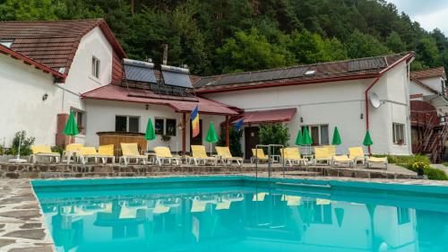 ein Hotel mit einem Pool vor einem Gebäude in der Unterkunft Pensiunea Alpin in Păltiniş