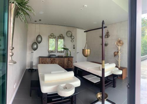 een salon met een witte stoel en een spiegel bij Villa Cerrado das Fontainhas SPA in Sintra