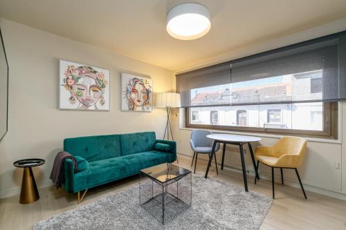 ein Wohnzimmer mit einem grünen Sofa und einem Tisch in der Unterkunft SUITE DE LUJO PUERTA DEL SOL+Parking in Vigo