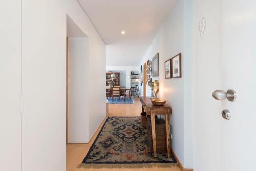 a hallway with a table and a rug at Between River and Sea Porto Apartment in Porto