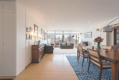 a dining room and living room with a table and chairs at Between River and Sea Porto Apartment in Porto