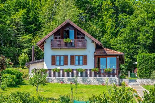 a house with a balcony on top of a yard at Holiday Home Mare near River in Karlovac