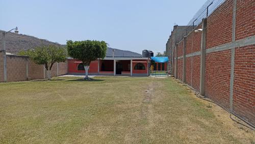 an empty courtyard of a brick building with a tree at Casa De Descanso Cuautla Morelos in Cuautla Morelos