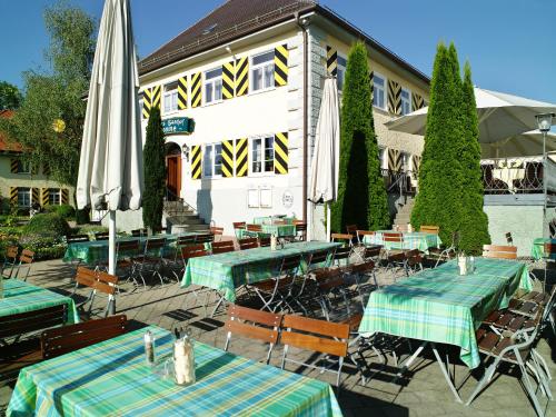 restauracja ze stołami i parasolami przed budynkiem w obiekcie Schloss-Gasthof Sonne w mieście Isny im Allgäu