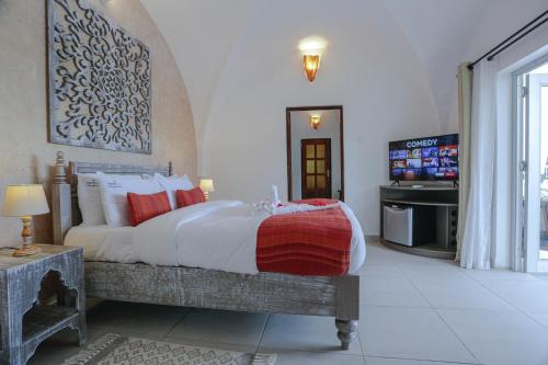 una camera con un grande letto e una televisione di Mzima Beach Residences - Diani Beach a Diani Beach