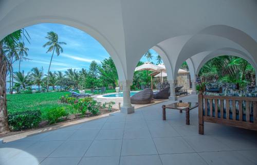 un padiglione con panchina e piscina di Mzima Beach Residences - Diani Beach a Diani Beach