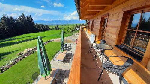 een balkon met stoelen en parasols in een hut bij Drevenica pod Demänovskou horou in Demanovska Dolina