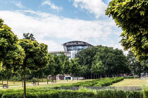 a building with a sign on it in a park at ATLANTIC Hotel Airport in Bremen