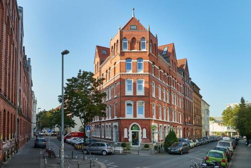 wysoki budynek z czerwonej cegły na ulicy miejskiej w obiekcie Hannover Business Home w Hanowerze