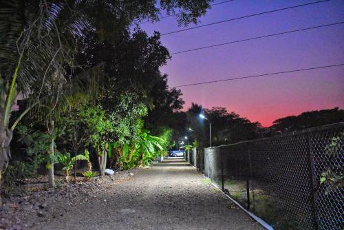 uma rua vazia à noite com uma cerca e árvores em Raghunandan Resort em Nashik