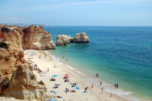 um grupo de pessoas numa praia perto do oceano em No More Snow, 300 m from the beach, king size bed, fast wi-fi em Portimão