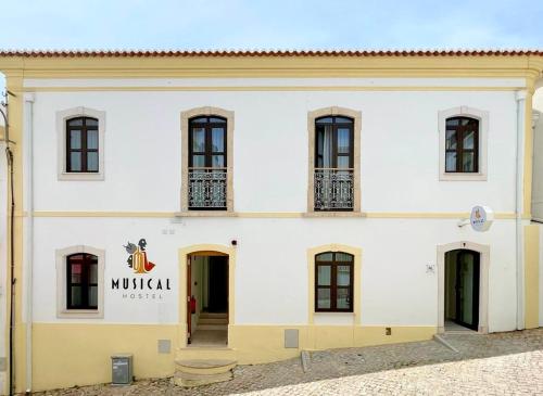 een wit gebouw met een bord met de tekst mulilla bij Musical Hostel in Albufeira