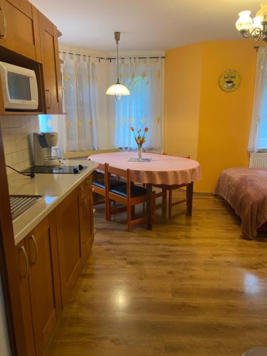 eine Küche mit einem Tisch und ein Zimmer mit einem Bett in der Unterkunft Alba Apartmany Železná Ruda in Železná Ruda