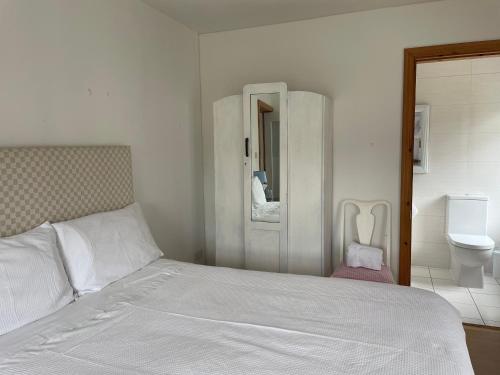 - une chambre blanche avec un lit et des toilettes dans l'établissement Kerry Country House, 