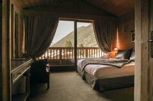 um quarto com uma cama e vista para uma montanha em Les Grands Montets Hotel & Spa em Chamonix-Mont-Blanc