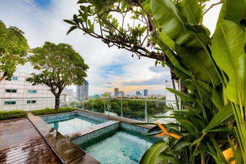 uma piscina num jardim com vista para a cidade em Cochin Sang Hotel em Cidade de Ho Chi Minh