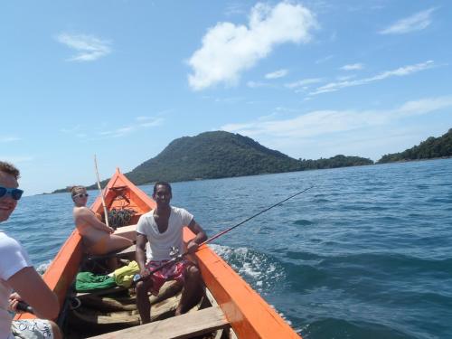 twee mannen op een boot met een hengel bij Daltons Banana Guesthouse in Banana Island