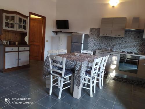 a kitchen with a table and chairs in a kitchen at Casa Margherita in Càbras