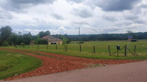 Gîte La Besse, Claudon في Claudon: طريق ترابي بجانب ميدان به سياج