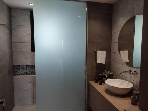 y baño con lavabo y espejo. en VagiaNa apartment Διαμέρισμα κοντά στο αεροδρόμιο, en Antimácheia