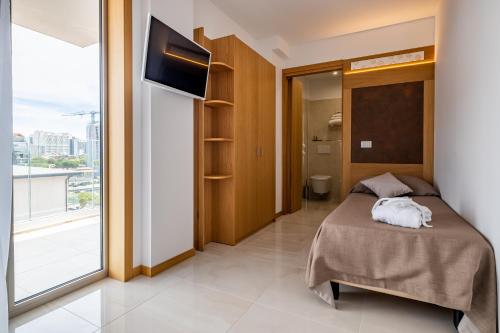 1 dormitorio con cama y ventana grande en Hotel Mare, en Lignano Sabbiadoro