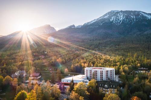 budynek w lesie z górą w tle w obiekcie Atrium Hotel - Family friendly w mieście Nový Smokovec