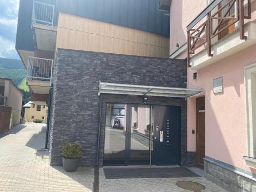 un ingresso a un edificio con porta nera di Residence Grand - soukromý apartmán a Špindlerův Mlýn