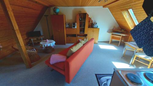 a living room with a red couch in a attic at Rummy's Ferienwohnung mit Garten in Wernigerode