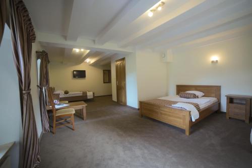 a bedroom with a bed and a desk and a chair at Hotel Stary Młyn in Suchedniów