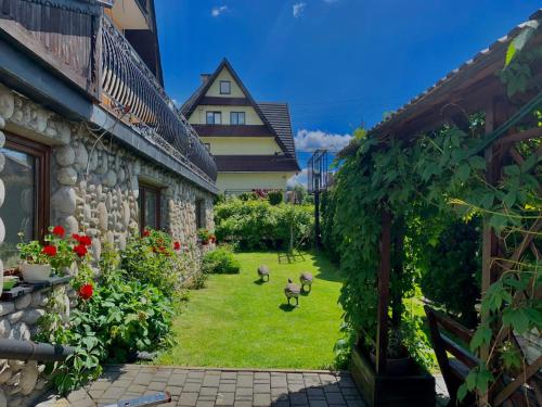 un giardino tra due edifici con polli nel cortile di Pokoje z własnymi aneksami kuchennymi - Zbigniew Lassak a Biały Dunajec