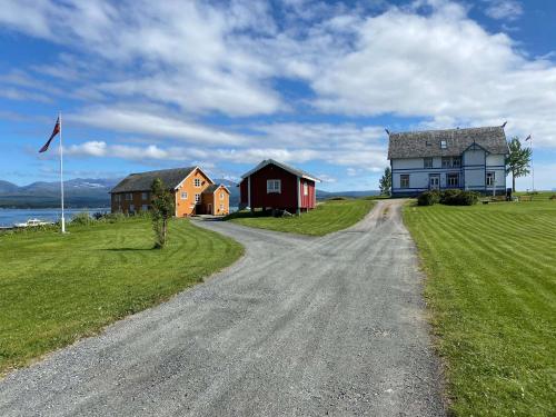 eine unbefestigte Straße vor einem Haus und einer Flagge in der Unterkunft Sandtorgholmen Hotel - Best Western Signature Collection in Harstad