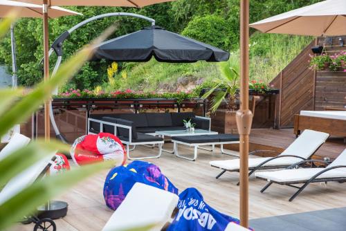 eine Terrasse mit einem Sonnenschirm, Stühlen und einer Bank in der Unterkunft Zarevata Guest House in Welingrad