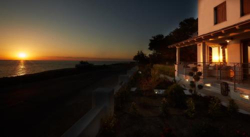 een huis met de zonsondergang op de achtergrond bij Sunrise Little in Chorefto