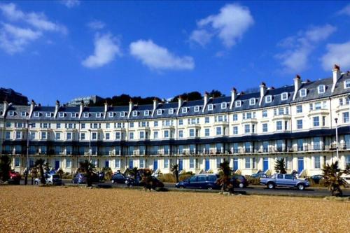 un gran edificio blanco con un cartel. en Beautifully appointed, period seaside apartment, en Folkestone