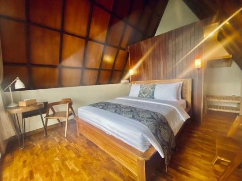 a bedroom with a bed and a table and a desk at Bukit Tiga Lima Boutique Hotel in Sajang