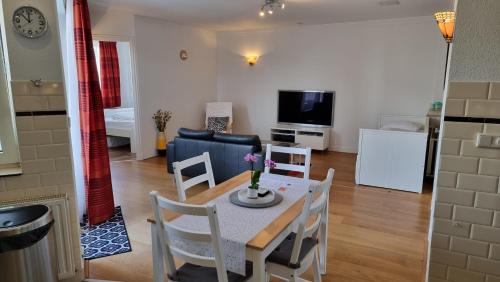 a dining room and living room with a table and chairs at Geräumiges und Modernes Apartment Tara am Meer mit Parkplatz! in Zandvoort