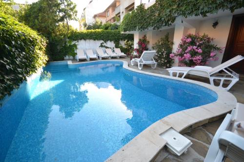 a swimming pool with lounge chairs next to a building at Семеен Хотел Море in Sozopol