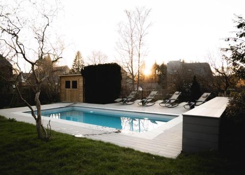 a swimming pool with lounge chairs in a yard at Il était une fois in Herbeumont