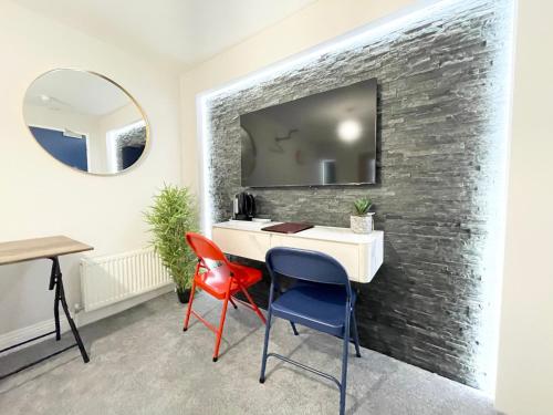 um quarto com uma secretária, 2 cadeiras e um espelho em Cloud9 Guest House - by Coastline Retreats - Newly Renovated, Beautiful Ensuite Rooms Near Seafront in Town Centre, Netflix, SuperFast WiFi, Communal Kitchen em Bournemouth