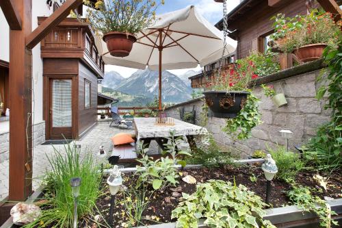 patio esterno con tavolo e ombrellone di Casa Grafa Bormio a Valdisotto