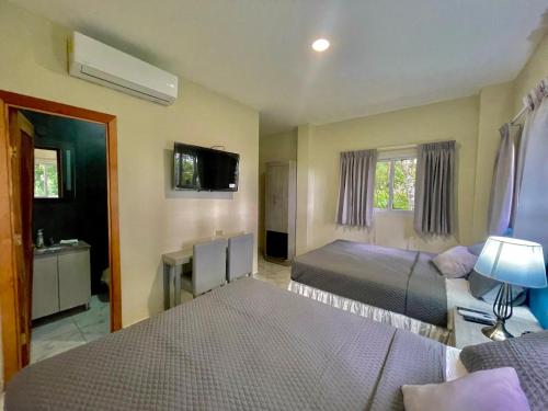 a hotel room with two beds and a television at Hotel Finca San Nicolas in San Salvador