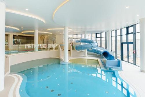 einem Pool mit Wasserrutsche in einem Gebäude in der Unterkunft Aqua Polanki Bodnar Apartments in Kołobrzeg