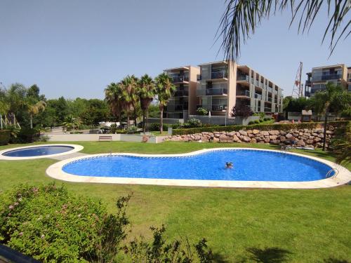 une piscine en face d'un grand bâtiment dans l'établissement Paradise Village Port Aventuras, à Salou