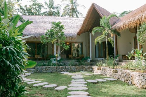 een tuin voor een huis bij Mana Eco Retreat in Kuta Lombok