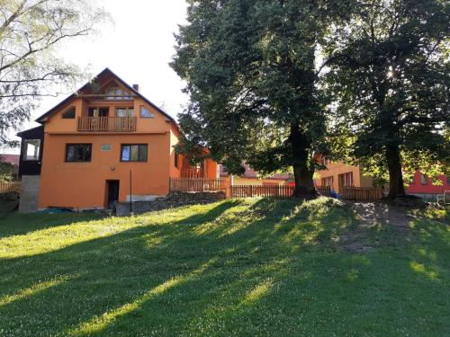 une maison orange avec un arbre en face dans l'établissement Kyprův mlýn, à Knínice