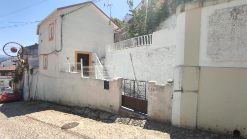 un bâtiment blanc avec une porte sur son côté dans l'établissement Lemon Tree House Coimbra - Courtyard garden with city views, à Coimbra