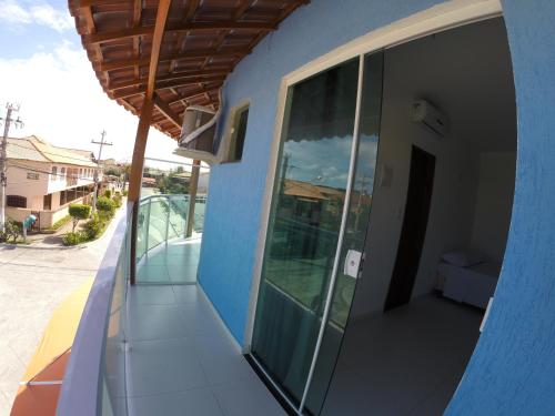 a side view of a blue building with a balcony at Xodó do Peró Suítes in Cabo Frio